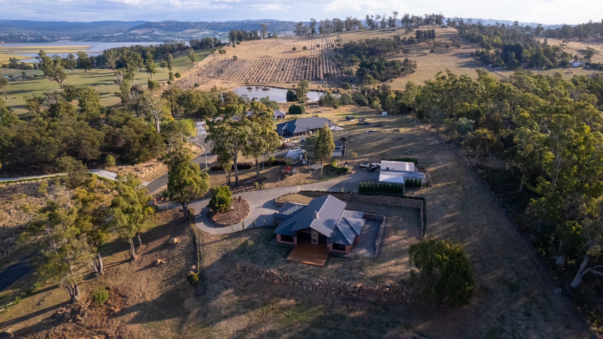 An aerial shot of a new home and the distant vacant land leading to the river